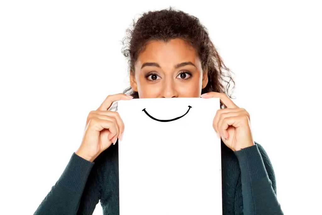 young african american woman with smile drawn on paper on white background